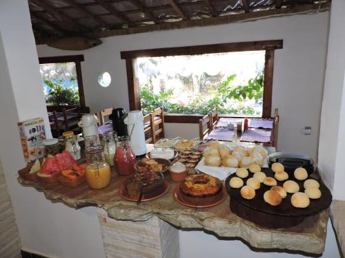 una mesa con comida en una habitación en Pousada Casa da Serra, en São Thomé das Letras