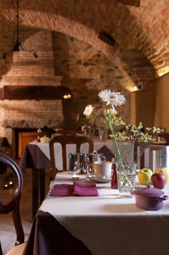 a table with a white table cloth and a vase of flowers at Boutique Hotel Villa dei Campi in Gavardo