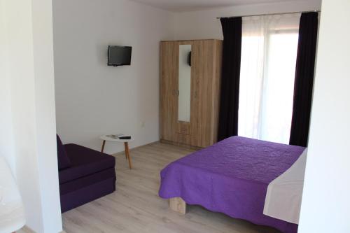 a bedroom with a purple bed and a window at Apartment Tip Top in Rovinj