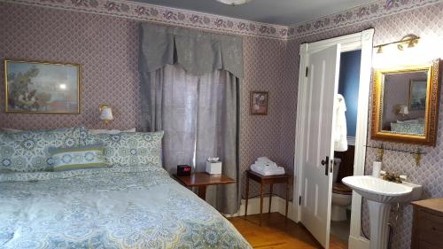a bedroom with a blue bed and a sink at Holidae House Bed & Breakfast in Bethel