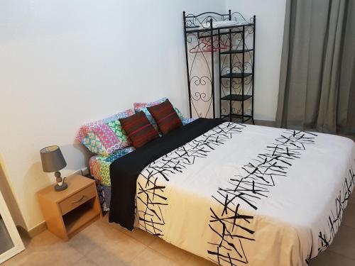 a bedroom with a bed and a table with a lamp at Casa Eloy in Setúbal
