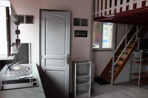 La salle de bains est pourvue d'une porte, d'un lavabo et d'escaliers. dans l'établissement Gîte Fleur de Mer La Rochelle, à Puilboreau