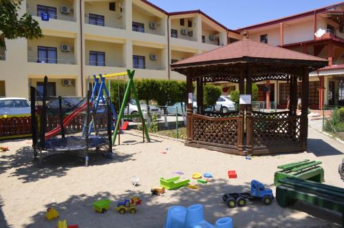 een speeltuin met een tuinhuisje en speelgoed in het zand bij Vila Poienita in Costinesti