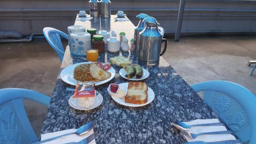 a blue table with plates of food on it at Red Dragon Hotel in Hsipaw