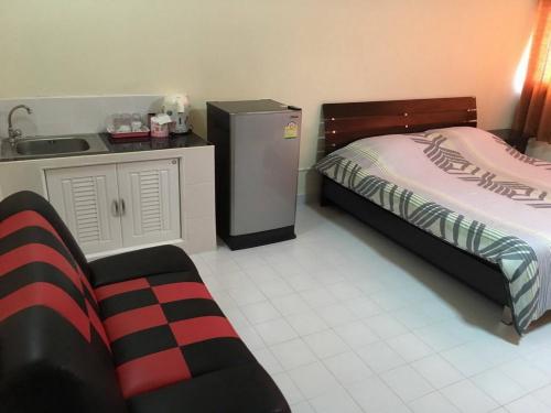 Schlafzimmer mit einem Bett, einem Waschbecken und einem Kühlschrank in der Unterkunft Condo Muang Thong in Nonthaburi