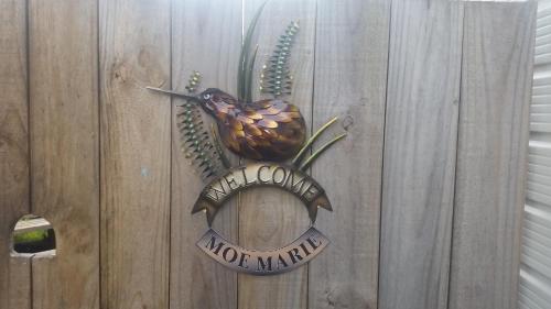Znak na drewnianym płocie z ptakiem w obiekcie Moe Marie Sleep Peacefully w mieście Turangi