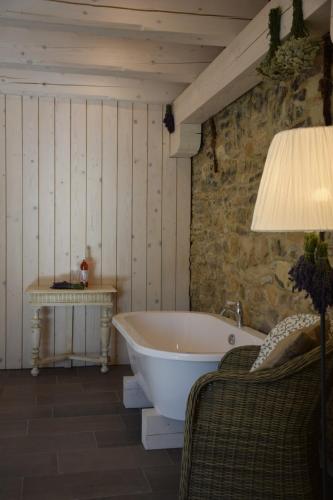 a bathroom with a tub and a table and a lamp at Sárffy House in Dörgicse