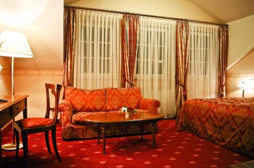 a hotel room with a couch and a bed at Parkhotel Idar-Oberstein in Idar-Oberstein