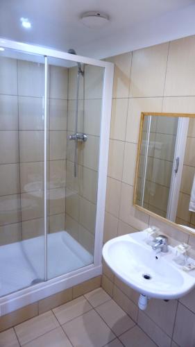 une salle de bain avec douche et lavabo dans l'établissement Hôtel Liège Strasbourg, à Paris