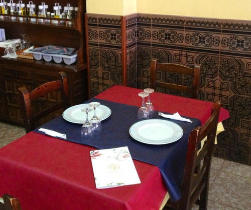 uma mesa de jantar com uma toalha de mesa vermelha e azul em Hostal Casa Paco em Chilches