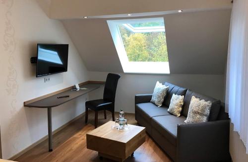 a living room with a couch and a table and a television at Haus Hohenzollern & Haus 'Ambiente in Bad Bertrich
