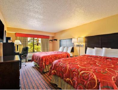 En eller flere senge i et værelse på Super 8 by Wyndham Texarkana AR