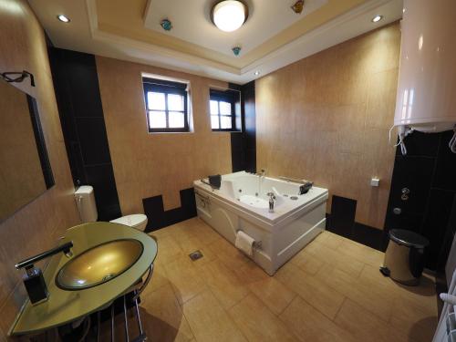 a large bathroom with a tub and a sink at Guest house DON-lux in Pljevlja