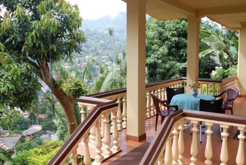 a house with a balcony with a table on it at Evergreen in Kandy
