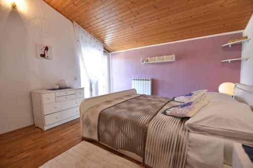 a bedroom with a bed and a wooden ceiling at Apartments Nena in Pula