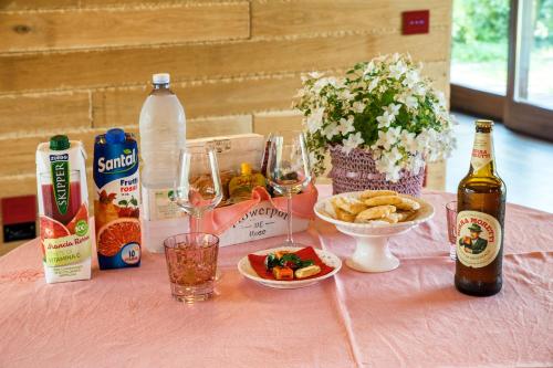 a pink table topped with bottles of beer and food at Dolce Casetta in Faenza