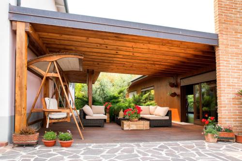 a wooden patio with couches and chairs on a building at Dolce Casetta in Faenza