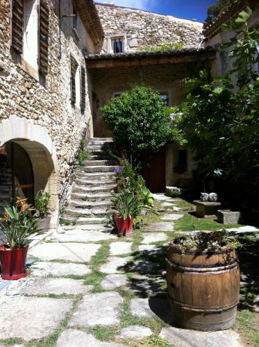a stone building with a staircase and a large barrel at Le Mas de la Roche in Montbrison-sur-Lez