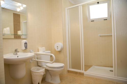 Un baño con inodoro, lavabo y ducha. en Hostal Casa Paco, en Chilches