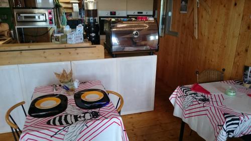 two tables in a kitchen with a counter with food at Countryside Eco Natuurhuisjes in Ee