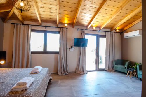a bedroom with a bed in a room with windows at Minoos Hotel in Chania Town