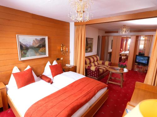 a hotel room with a bed and a living room at Berger's Sporthotel in Saalbach Hinterglemm