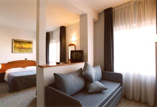 ポルト・サン・ジョルジョにあるHotel La Terrazzaのソファとベッド付きのホテルルーム