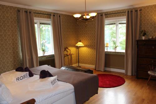 a hotel room with two beds and two windows at B&B på Frösön in Östersund