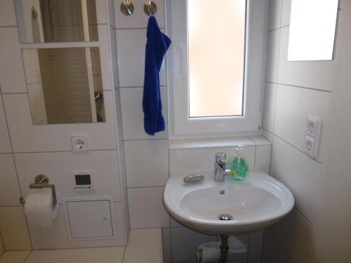 een witte badkamer met een wastafel en een raam bij Ferienhaus im Nordschwarzwald in Pforzheim
