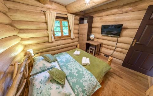 a room with two beds in a log cabin at BeaR's LOG in Seliste Dreznicko