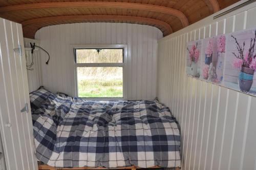 1 dormitorio con cama y ventana en Sitting at the Bay en Zuiderwoude