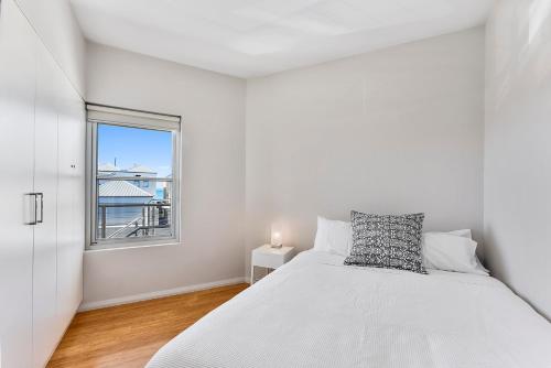 a white bedroom with a bed and a window at Robe Marina Accommodation in Robe