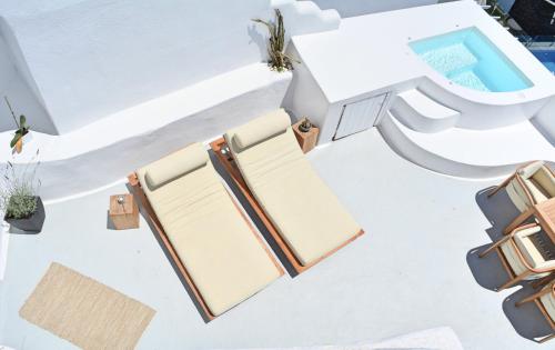 a room with a table and chairs and a toilet at Cocoon Suites in Imerovigli