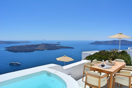 a patio with a pool and a table and chairs at Cocoon Suites in Imerovigli