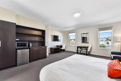 a hotel room with a large bed and a kitchen at Robe Marina Accommodation in Robe