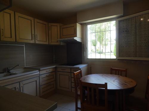 une cuisine avec une table en bois et une fenêtre dans l'établissement T3 Les Peupliers proche Pasino et mer, à La Grande Motte