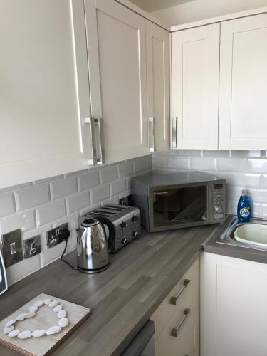 a kitchen with a counter top with a microwave at Pavilion Holiday Apartments in Weston-super-Mare