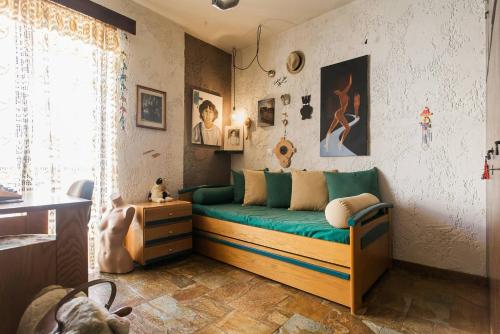 um quarto com um sofá verde num quarto em The Rustic Hug em Atenas