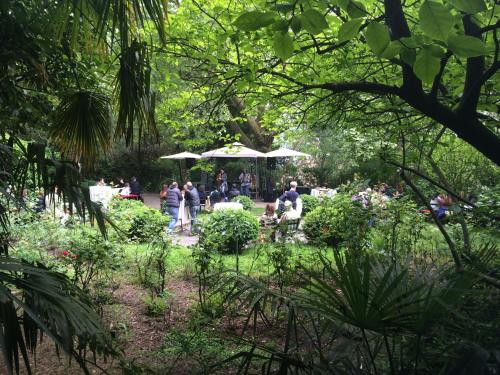 a group of people in a garden with umbrellas at Schloss-Castel Pienzenau - Guestrooms & Apartments - B&B-Hotel & Restaurant in Merano