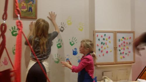 a woman and a little girl painting a wall at Apartments Teglbauernhof, Hütte, Chalet, Mobilheim, Appartement, Ferienwohnung, Pension, Urlaub in Uttendorf