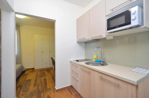 a kitchen with a sink and a microwave at Stella Apartments in Novigrad Istria