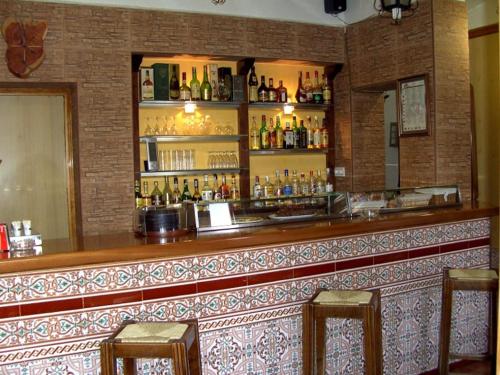 a bar in a restaurant with two bar stools at El Ciervo in Villaciervos
