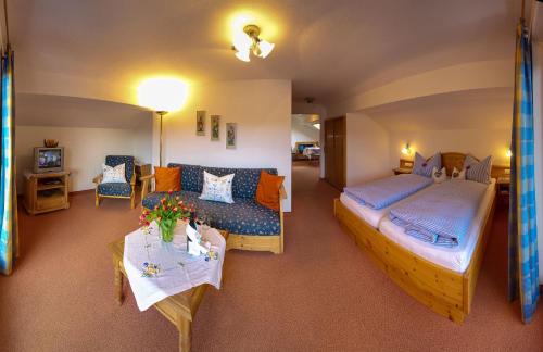克倫的住宿－Gästehaus Alpina，客房设有两张床、一张沙发和一张桌子。