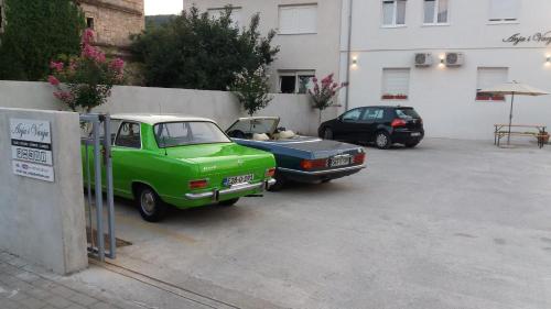 two cars parked in a parking lot next to a building at Guest House Vanja in Mostar