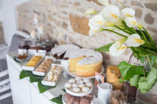 a table with various pastries and a vase with flowers at Residenza Amblingh in Vasto