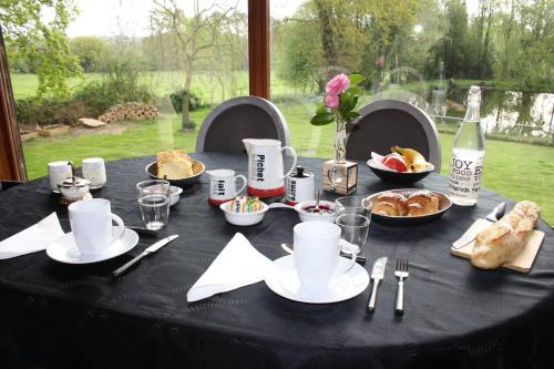 uma mesa com uma toalha de mesa preta com comida em Chambres d'hôtes la landrière em Mauléon