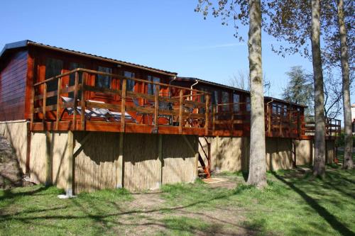 a wooden house with a balcony on top of a wall at Chambres d'hôtes la landrière in Mauléon