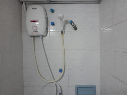 a shower in a bathroom with a blow dryer at Centerpoint Hotel in Trang