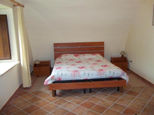 ein Schlafzimmer mit einem Bett in einem Zimmer mit einem Fenster in der Unterkunft Il Mulino in Maremma in Farnese