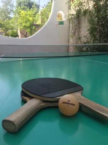 2 raquettes de ping-pong et un ballon sur une table dans l'établissement Costa Residence Vacanze, à Lipari